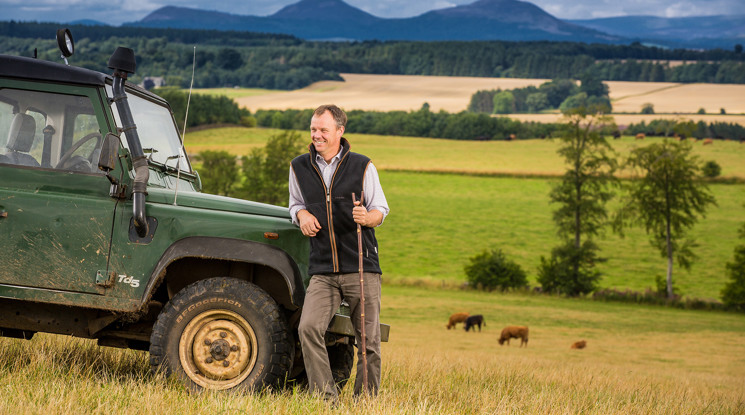Farmer in field next to Land Rover